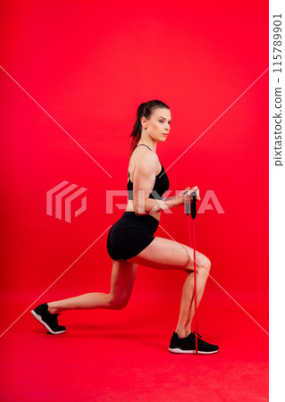 Athletic female performs exercises using a resistance band. Strength and motivation 115789901