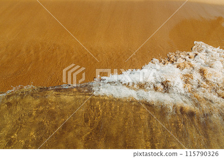 concept for perfumes, smells, heat, freshness, coolness and other associations. Ripple sea ocean water surface with small waves. Ocean water foam splashing. Copy space. sandy beach with waves rolling 115790326