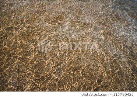 sandy beach with waves rolling in, creating a beautiful natural background. beige sand contrasts with ocean waves. concept for perfumes, smells, heat, freshness, coolness and other associations 115790425