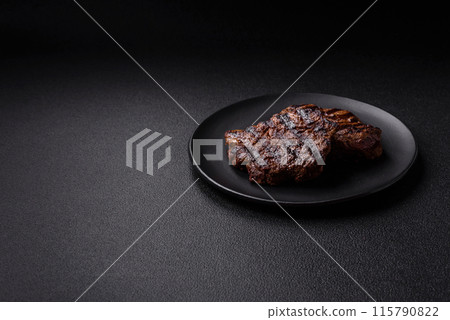 Fresh juicy delicious beef steak on a dark background Fresh juicy delicious beef steak on a dark background 115790822