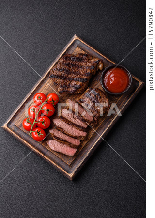 Fresh juicy delicious beef steak on a dark background 115790842