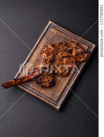 Juicy beef tomahawk steak on the bone baked on the grill Juicy beef tomahawk steak on the bone baked on the grill 115790891