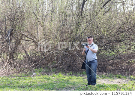 A young man videotaping on a smartphone. Uses gimbal to get smooth shots. Controls the recording by touching the screen. A young man videotaping on a smartphone. Uses gimbal to get smooth shots. Controls the recording by touching the screen. 115791184