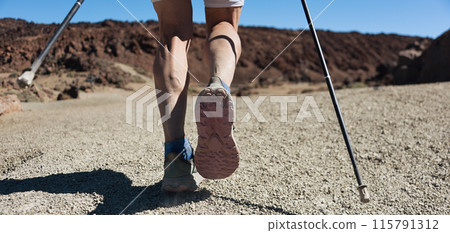 Man hiking in mountains adventure and exercising. Nordic walking in sunny summer nature outdoors. Legs and sport shoes walk Man hiking in mountains adventure and exercising. Nordic walking in sunny summer nature outdoors. Legs and sport shoes walk 115791312
