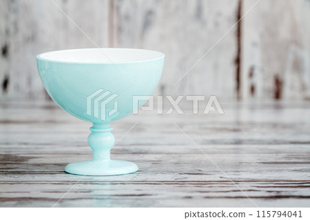 Single Turquoise Ice Cream Bowl on a White Wooden Background, Aesthetic Serveware with Copy Space 115794041