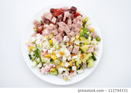 A varied salad on a white plate. Meat and vegetable salad. Delicious breakfast. A varied salad on a white plate. Meat and vegetable salad. Delicious breakfast. 115794331