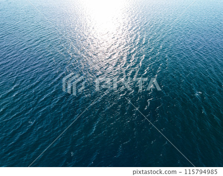 Aerial view of a blue sea surface water texture background,Sun reflections over ocean, Aerial flying drone view Waves water surface texture on sunny tropical ocean in Phuket island Thailand 115794985