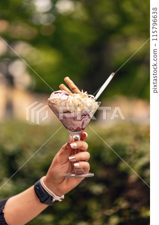 Woman is holding a glass cup of ice cream 115796638