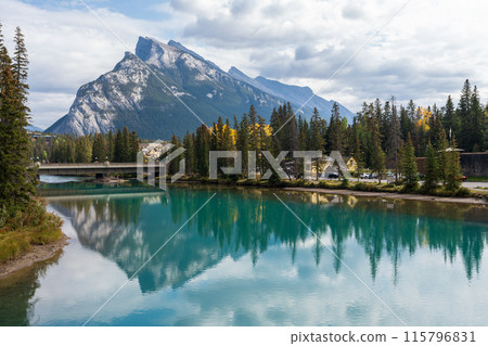 Banff Central Park Trail scenery reflected on Bow River in autumn. Mount Rundle Mountain Range in the background. Banff National Park, Alberta, Canada. Banff Central Park Trail scenery reflected on Bow River in autumn. Mount Rundle Mountain Range in the background. Banff National Park, Alberta, Canada. 115796831