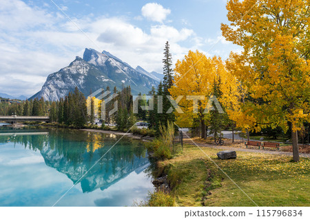 Banff Central Park Trail scenery reflected on Bow River in autumn. Mount Rundle Mountain Range in the background. Banff National Park, Alberta, Canada. Banff Central Park Trail scenery reflected on Bow River in autumn. Mount Rundle Mountain Range in the background. Banff National Park, Alberta, Canada. 115796834