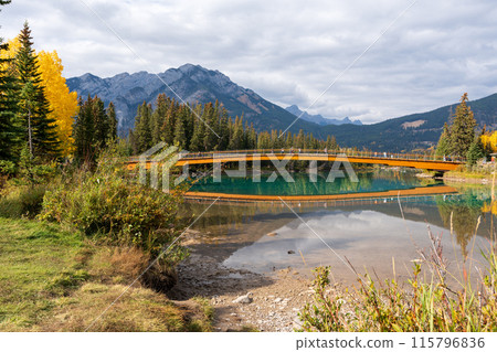Nancy Pauw Bridge, Town of Banff Central Park Trail natural scenery reflected on Bow River in autumn day. Banff National Park, Alberta, Canada. Canadian Rockies. Nancy Pauw Bridge, Town of Banff Central Park Trail natural scenery reflected on Bow River in autumn day. Banff National Park, Alberta, Canada. Canadian Rockies. 115796836