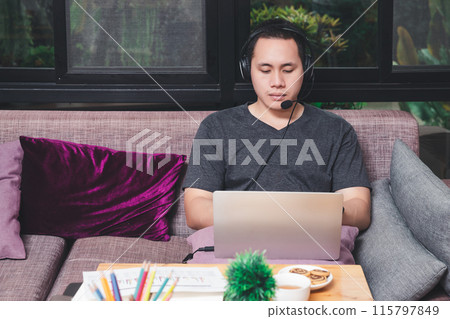 Businessman meeting online via video call on laptop in home office. Man wear headphone video calling or distance education e-leaning online course. 115797849