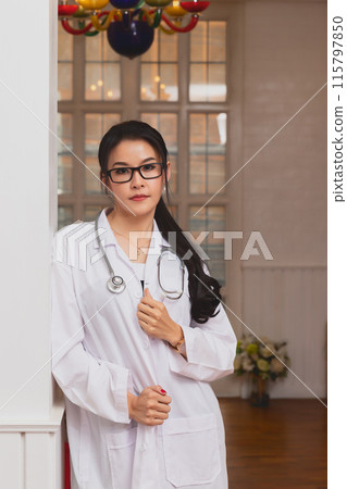 Portrait of female doctor with a stethoscope in white uniform standing in a hospital. 115797850