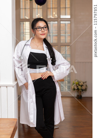 Portrait of female doctor with a stethoscope in white uniform standing in a hospital. 115797851