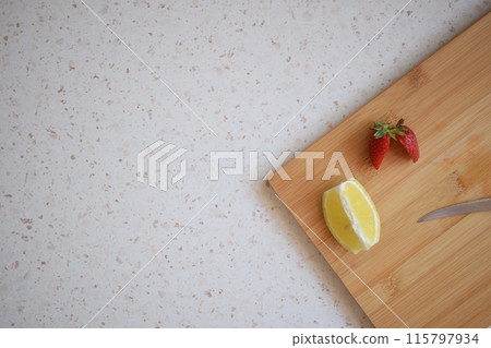 Lemon and strawberries cut on the kitchen counter 115797934