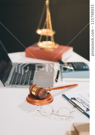 Male lawyer working with contract papers and wooden gavel on tabel in courtroom. justice and law ,attorney, court judge, concept. Male lawyer working with contract papers and wooden gavel on tabel in courtroom. justice and law ,attorney, court judge, concept. 115798933