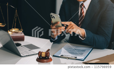 Male lawyer working with contract papers and wooden gavel on tabel in courtroom. justice and law ,attorney, court judge, concept. Male lawyer working with contract papers and wooden gavel on tabel in courtroom. justice and law ,attorney, court judge, concept. 115798959