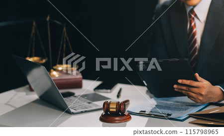 Male lawyer working with contract papers and wooden gavel on tabel in courtroom. justice and law ,attorney, court judge, concept. Male lawyer working with contract papers and wooden gavel on tabel in courtroom. justice and law ,attorney, court judge, concept. 115798965