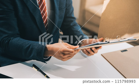 Male lawyer working with contract papers and wooden gavel on tabel in courtroom. justice and law ,attorney, court judge, concept. Male lawyer working with contract papers and wooden gavel on tabel in courtroom. justice and law ,attorney, court judge, concept. 115798993