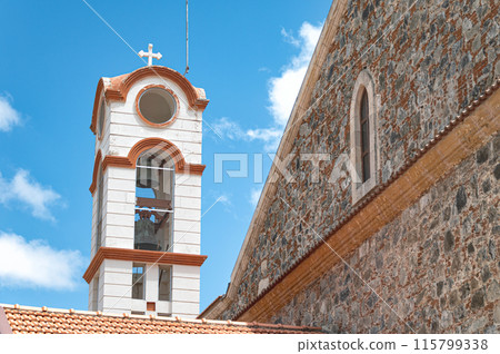 White bell tower with a tiled roof standing out against a blue sky. Panagia Eleousa church, Agros, Cyprus White bell tower with a tiled roof standing out against a blue sky. Panagia Eleousa church, Agros, Cyprus 115799338