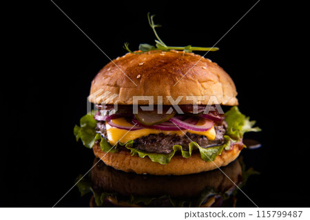 Burger with beef, cheese, vegetables on black plate. Dark Background. Close up. Burger with beef, cheese, vegetables on black plate. Dark Background. Close up. 115799487