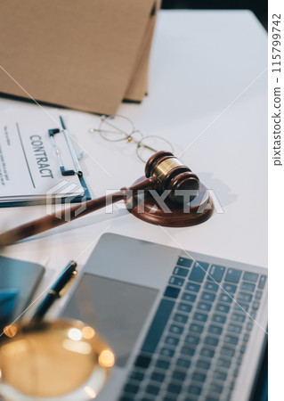 Male lawyer working with contract papers and wooden gavel on tabel in courtroom. justice and law ,attorney, court judge, concept. Male lawyer working with contract papers and wooden gavel on tabel in courtroom. justice and law ,attorney, court judge, concept. 115799742
