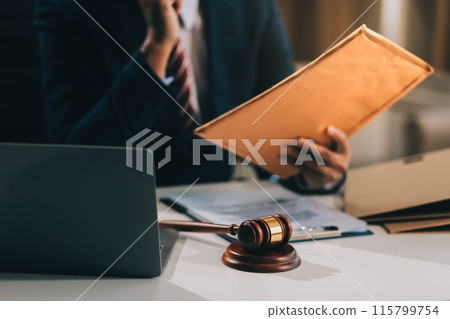 Male lawyer working with contract papers and wooden gavel on tabel in courtroom. justice and law ,attorney, court judge, concept. Male lawyer working with contract papers and wooden gavel on tabel in courtroom. justice and law ,attorney, court judge, concept. 115799754