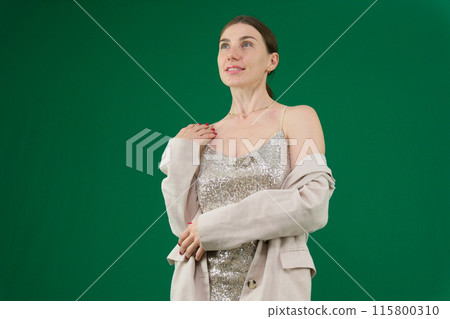 woman dances on green background chromakey woman in a beautiful Silver dress and jackets smiles opens the jacket shows beautiful teeth hair well-groomed dear girl woman dances on green background chromakey woman in a beautiful Silver dress and jackets smiles opens the jacket shows beautiful teeth hair well-groomed dear girl 115800310