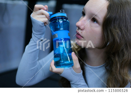 Gym girl drinks water Fit woman runner outdoors holding water bottle. Fitness woman taking a break after running workout. 115800326