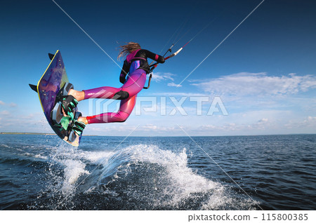 professional kiter performs a difficult trick on a beautiful background with splashes of water from the sea and a cloudy sky professional kiter performs a difficult trick on a beautiful background with splashes of water from the sea and a cloudy sky 115800385