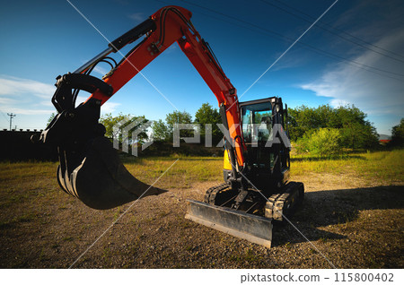 Close-up wide angle image of an excavator working on an agricultural farm in a forest belt 115800402