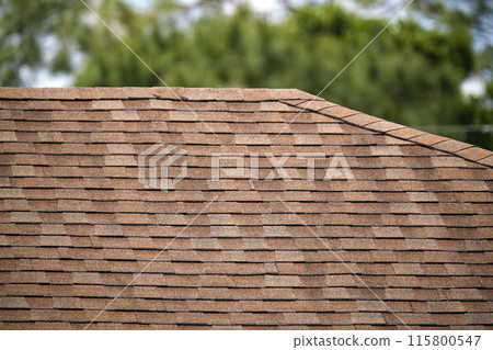 Closeup of house roof top covered with asphalt or bitumen shingles. Waterproofing of new building Closeup of house roof top covered with asphalt or bitumen shingles. Waterproofing of new building 115800547