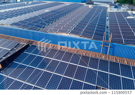 Aerial view of blue photovoltaic solar panels mounted on industrial building roof for producing green ecological electricity. Production of sustainable energy concept 115800557