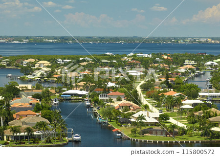 Aerial view of residential suburbs with private homes located on gulf coast near wildlife wetlands with green vegetation on sea shore. Living close to nature concept Aerial view of residential suburbs with private homes located on gulf coast near wildlife wetlands with green vegetation on sea shore. Living close to nature concept 115800572