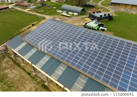 Aerial view of farm building with photovoltaic solar panels mounted on rooftop for producing clean ecological electricity. Production of renewable energy concept 115800641