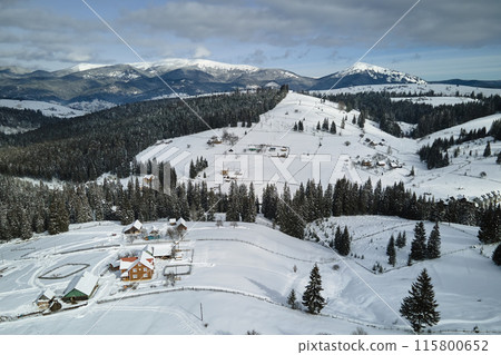 Winter landscape with small village houses between snow covered forest in cold mountains 115800652