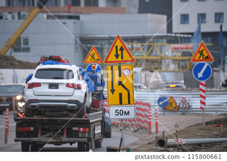 Roadworks warning traffic signs of construction work on city street and slowly moving cars 115800661