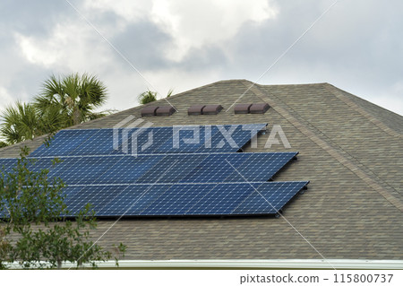 Residential house with rooftop covered with solar photovoltaic panels for producing of clean ecological electrical energy in suburban rural area. Concept of autonomous home Residential house with rooftop covered with solar photovoltaic panels for producing of clean ecological electrical energy in suburban rural area. Concept of autonomous home 115800737