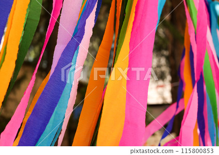Close-up of colorful ribbon strips hanging outdoors Close-up of colorful ribbon strips hanging outdoors 115800853