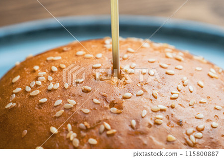 Sesame seed bun with a wooden skewer stick 115800887