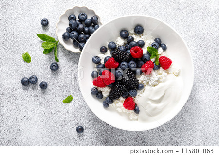 Cheese cottage with yogurt and fresh berries. Curd with blueberry, raspberry and blackberry, top view 115801063