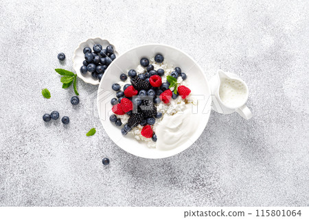 Cheese cottage with yogurt and fresh berries. Curd with blueberry, raspberry and blackberry, top view 115801064