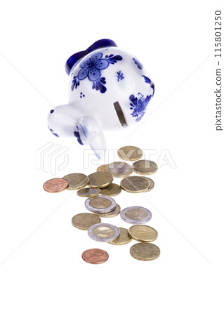 Piggy bank in a shape of a cow with blue ornament and scattered coins 115801250