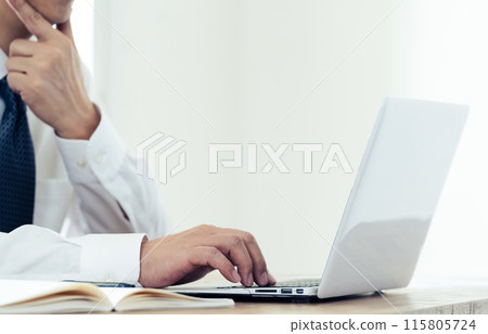 Hand of a man working on a laptop 115805724