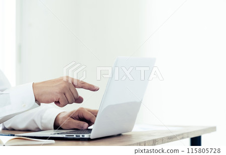 Hand of a man working on a laptop 115805728