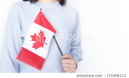 Unrecognized girl student in white blue shirt holding small Canadian flag over gray background, Canada day, holiday, vote, immigration, tax, copy space 115806122