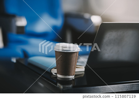 Asian businessman enjoying enjoys a coffee comfortable flight while sitting in the airplane cabin, Passengers near the window. Asian businessman enjoying enjoys a coffee comfortable flight while sitting in the airplane cabin, Passengers near the window. 115807119