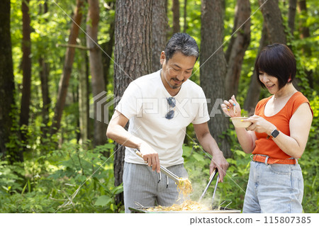 A couple in their 50s enjoying a BBQ 115807385