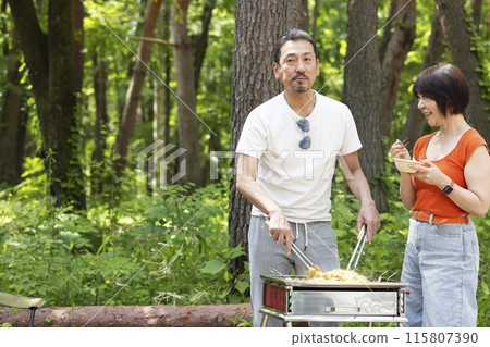 A couple in their 50s enjoying a BBQ A couple in their 50s enjoying a BBQ 115807390