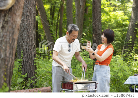 A couple in their 50s enjoying a BBQ 115807455